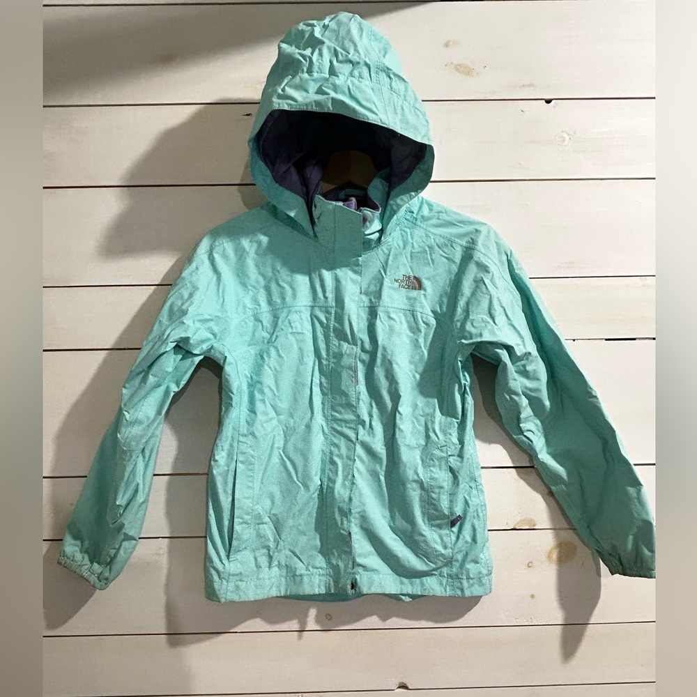 A north face rain jacket, color teal and the outside and purple on the inside